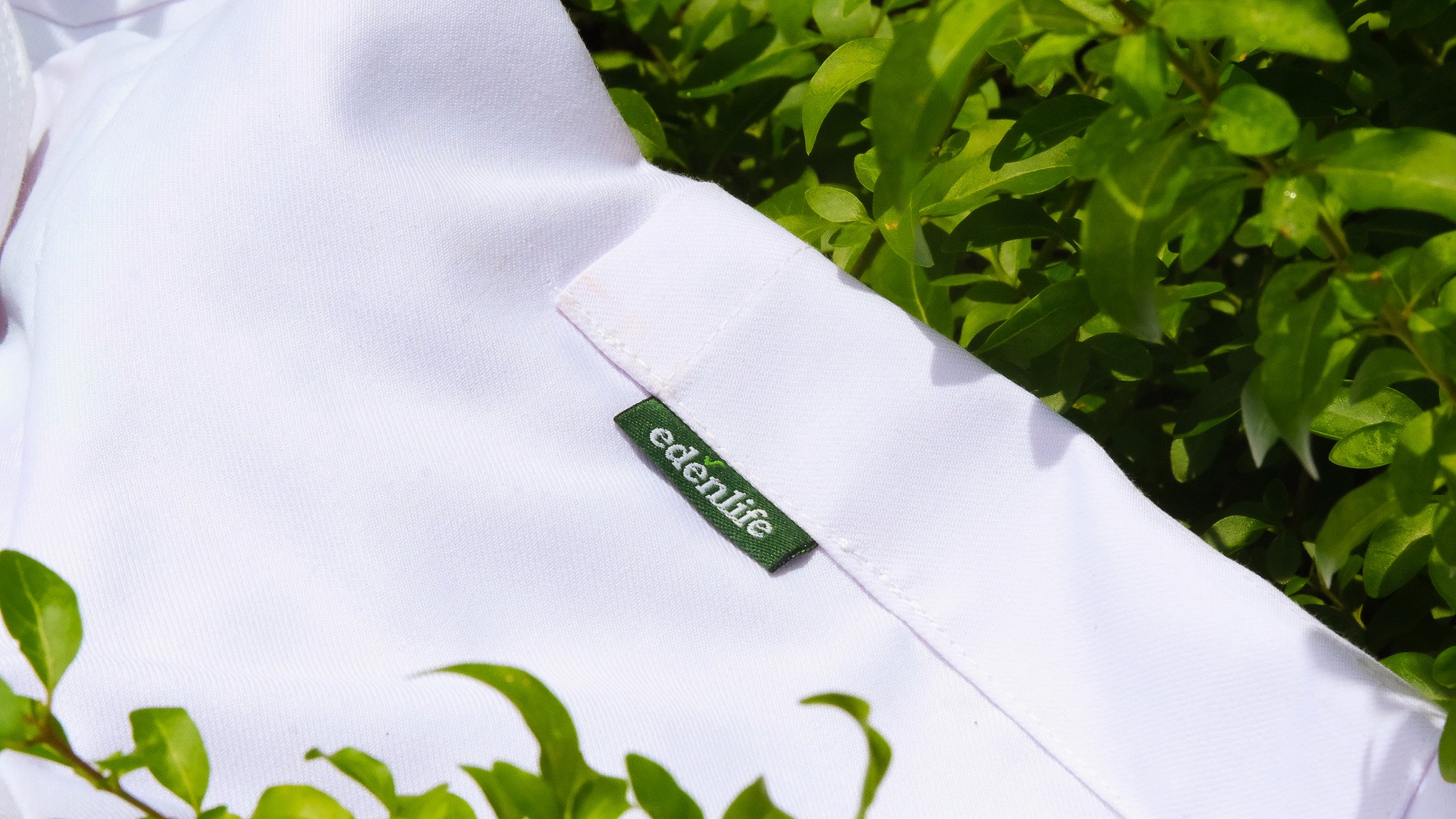 EdenLife garment label stitched into a white uniform